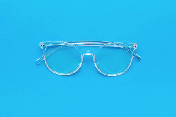 Transparent women's stylish glasses on a blue background. A fashionable tool for vision correction.