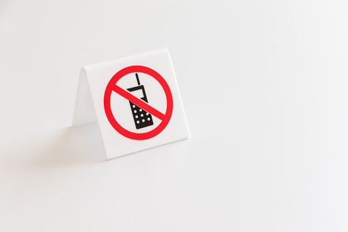 A sign prohibiting the use of mobile phones on the table