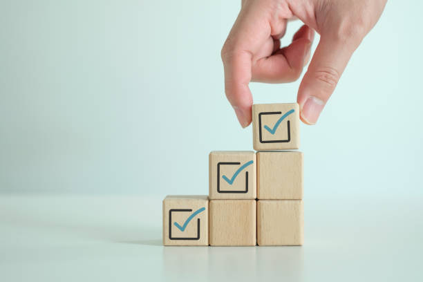 istock Hand put blue correct check mark into top of wooden stack to complete checklist. 2009229953