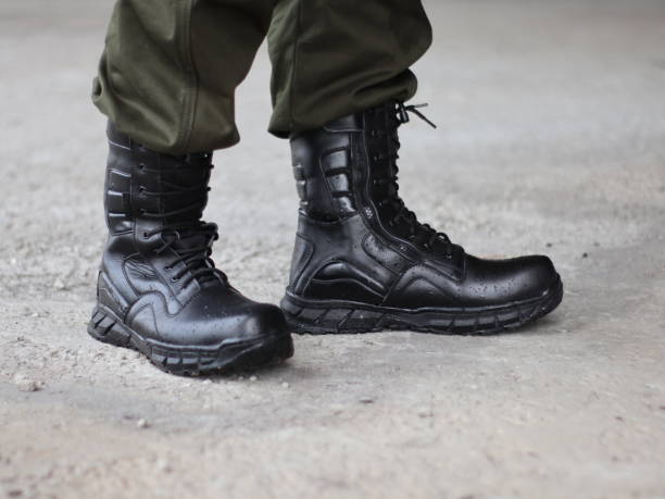 istock Man in black army boots with laces and green trousers 2009340251