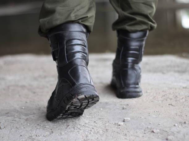 istock Man in black army boots with laces and green trousers 2009340764