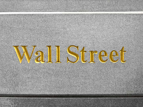 Close up photo of  Wall Street sign carved on a building in New York City