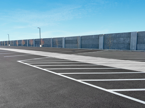 Empty parking lot surrounded by tall concrete walls