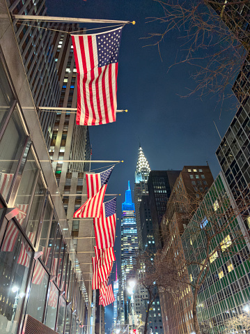 Waving American flag on the background of skyscraper in New York, usa. Motto of NY - Excelsior!