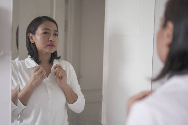 istock Woman standing and looking at herself in the mirror 2009377995