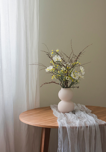 A beautiful homemade spring bouquet on a round wooden table in the living room