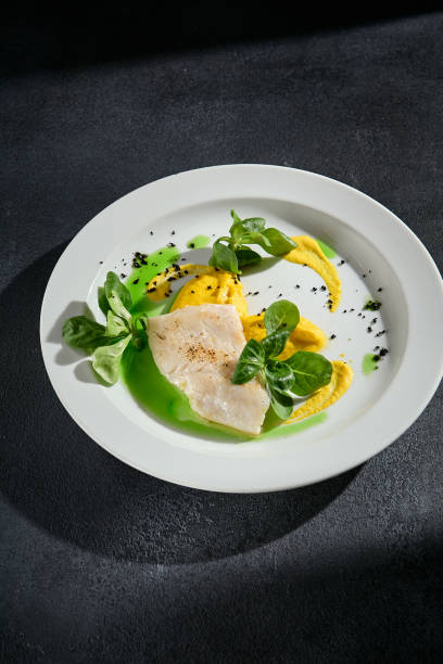 istock Gourmet cod steak with dual sauces on a contemporary plate, perfect for modern cuisine presentations 2009428534