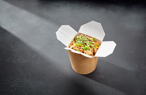 Soba noodles with chicken in a creamy sauce, served in a takeaway box for a convenient and flavorful meal on the go.