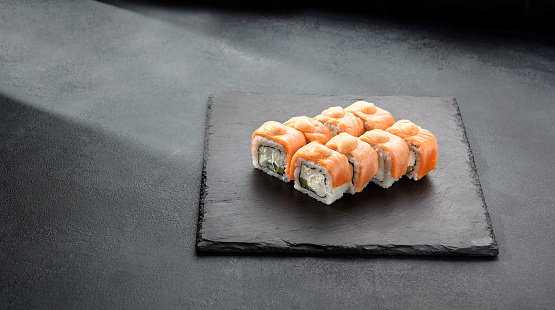 Baked Philadelphia sushi rolls with spicy sauce, offering a creamy and tangy taste in each bite.