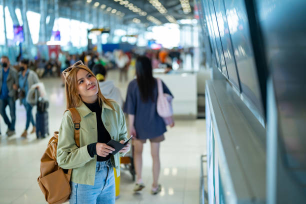istock Asian woman looking timetable at airport terminal. 2009431715