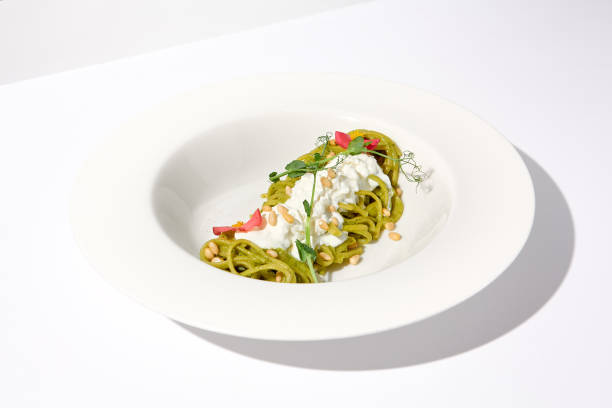 istock Pesto Pasta with Stracciatella Cheese Garnished with Pine Nuts and Edible Flowers, Perfect for Modern Italian Cuisine 2009439008