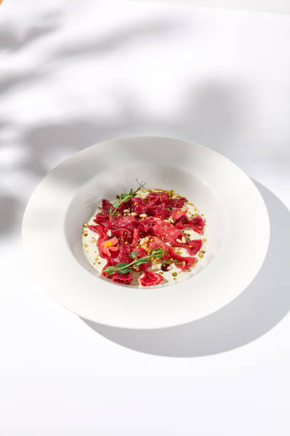 istock Beetroot Ravioli Bows with Cream Sauce and Leaf Shadow, Elegance on a Plate for Fine Dining Experiences 2009439011