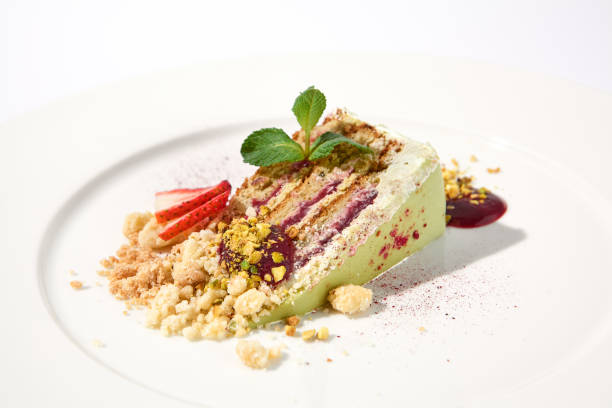 istock Pistachio cake with a raspberry layer and crumbled cookie and pistachio topping on an isolated white background 2009439543