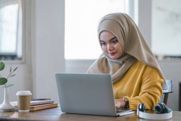 istock Muslim entrepreneur focused on work at her laptop in a bright office space. 2009445323