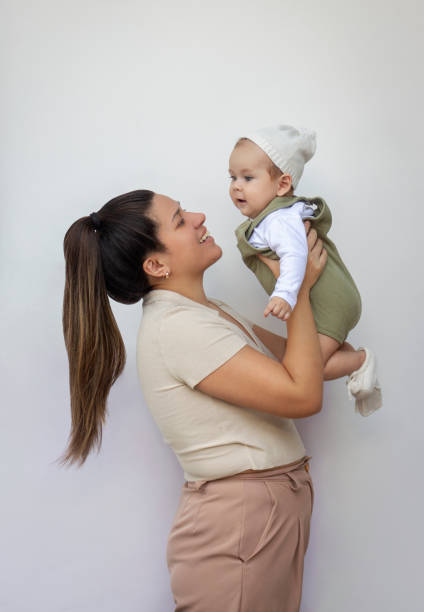 istock Smiling young mother holding her baby on a white background 2009508198