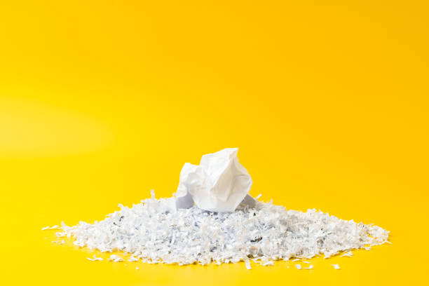 istock Shredded white paper on light yellow background 2009509333