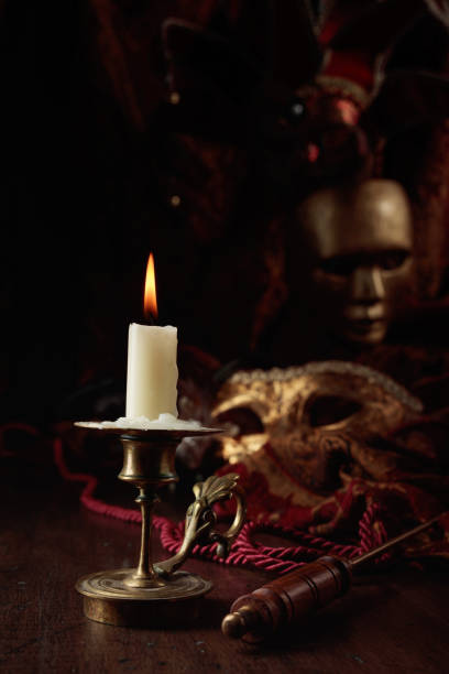 istock Burning candle in an old brass candlestick and carnival masks. 2009516153