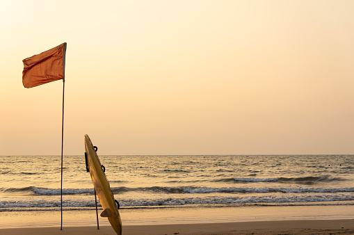 sunset on the sea, flag, surfboard