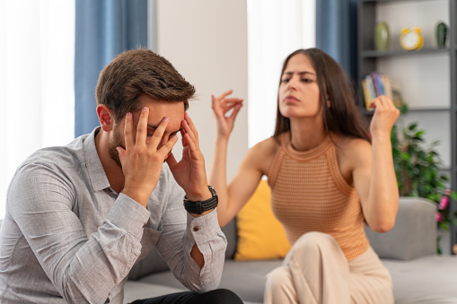 Young man frustrated by his girlfriend who constantly argues with him