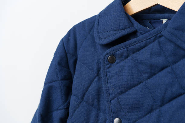 istock Blue quilted kids coat on hanger against white wall 2009593276