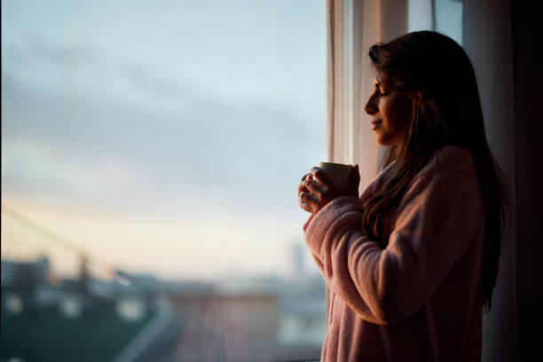 istock Smiling woman enjoying by the window. 2009645413