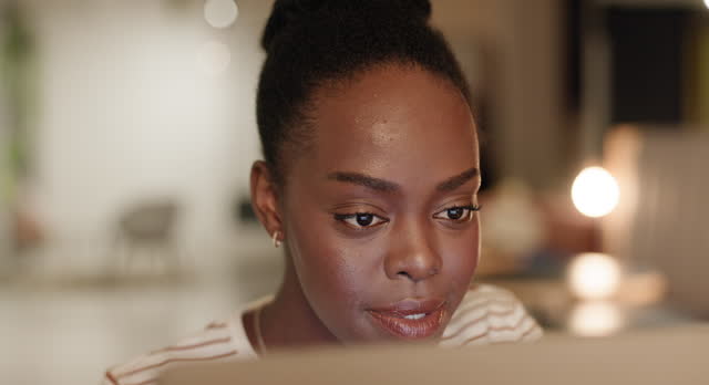 Night, business or face of black woman on computer for networking, blog or email in workplace. Technology, laptop or employee in office typing online on social media website for editing or research