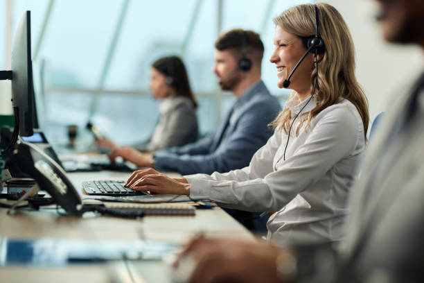Female customer service representative working on PC in a call center.