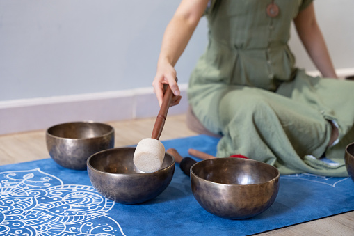 A detailed image displays a singing bowl instrument placed on a blue mat