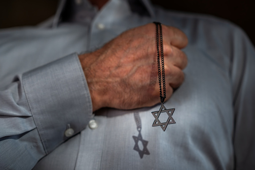 Man holding a necklace with Star of David