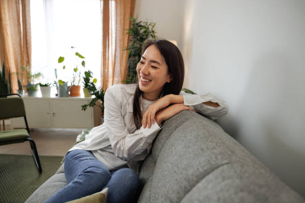 istock Young beautiful cheerful woman sitting on a sofa at home 2009687053