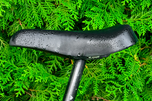 Close-up of a wet old leather bicycle saddle