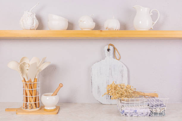 istock Bright kitchen space in a modern kitchen. Towels in a metal basket, a set of kitchen tools. Decorative pumpkins on an open wooden shelf. Front view. 2009687891