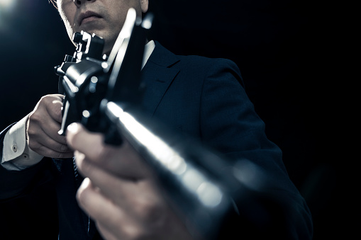 Businessman in Suit Aiming Automatic Rifle with Precision