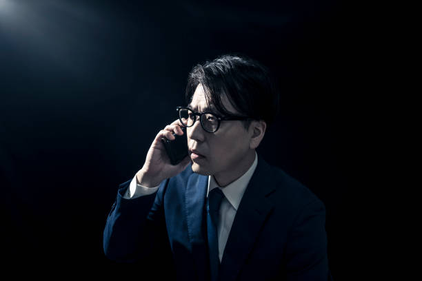 istock Businessman in Suit Making Phone Call on Smartphone in Dimly Lit Room 2009689370