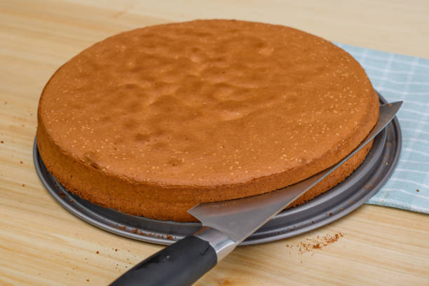 istock A round brown sponge cake cut in half with a knife into two cake bases 2009689720