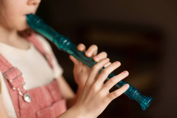istock child playing flute. learning to play musical instruments at music school 2009691859