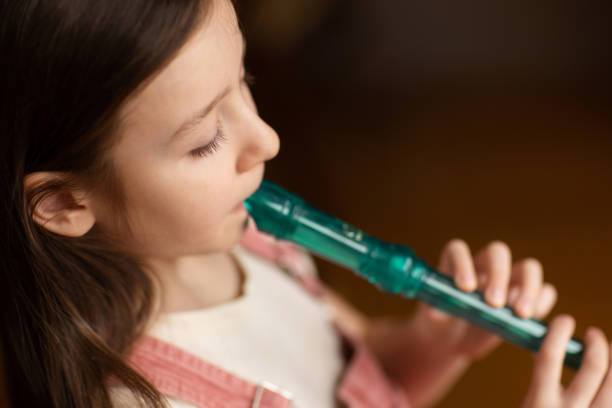 istock child playing flute. learning to play musical instruments at music school 2009691860