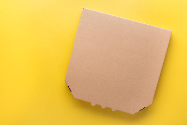 istock Pizza closed carton box on uniform yellow background flat lay mockup with blank space 2009693435