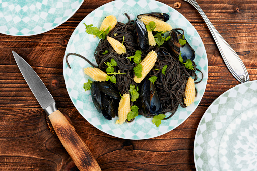 Vegan black bean pasta with boiled mussels. Spaghetti with seafood. Pasta vongole.