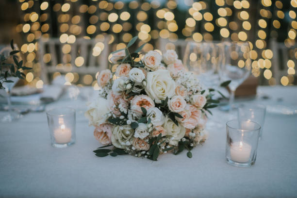 istock Beautiful bridal bouquet resting on the banquet table. Image illuminated by the light of candles and garlands. 2009724009