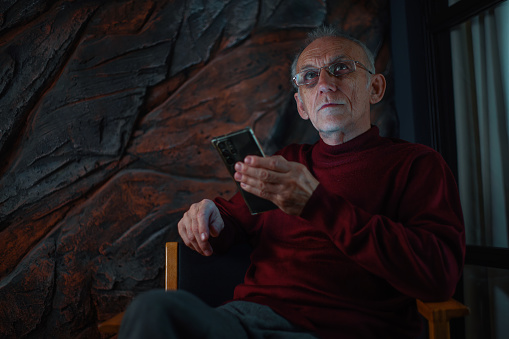 Man holding his phone against the decorative stone wall