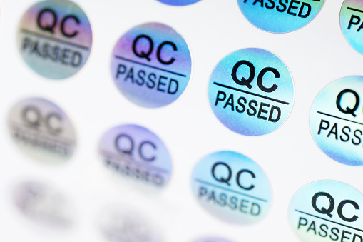 Close up of stickers with the text QC passed, to verify correct manufacturing.