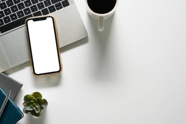 istock Top view of smartphone with empty screen, laptop and a coffee cup on white table 2009741487