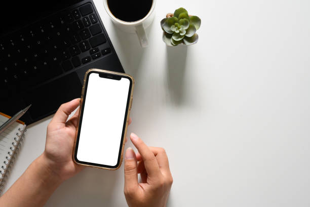 istock Woman using mobile phone at working desk. Top view, blank screen for your advertising text 2009742569