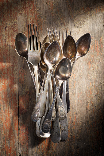 Close up of some old silver cutlery on a wood table