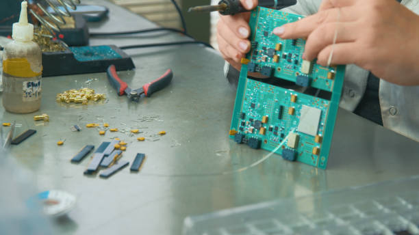 istock Worker holds a circuit board in his hands about to complete the details 2009761860