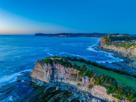 Aerial sunrise seascape with low cloud bank at The Skillion in Terrigal, NSW, Australia.