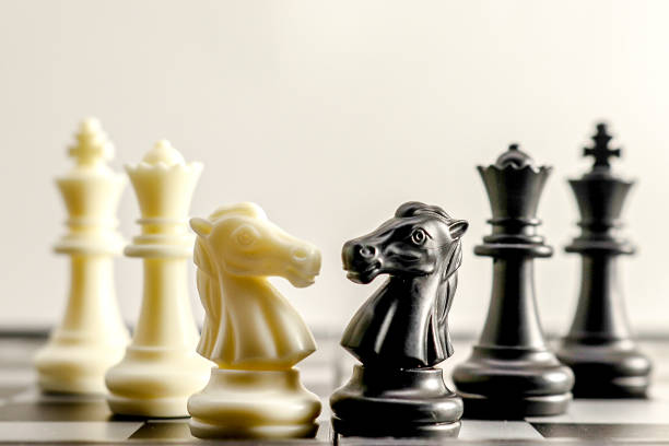 istock several chess pieces standing on a chess board with light coming through the pieces 2009802592