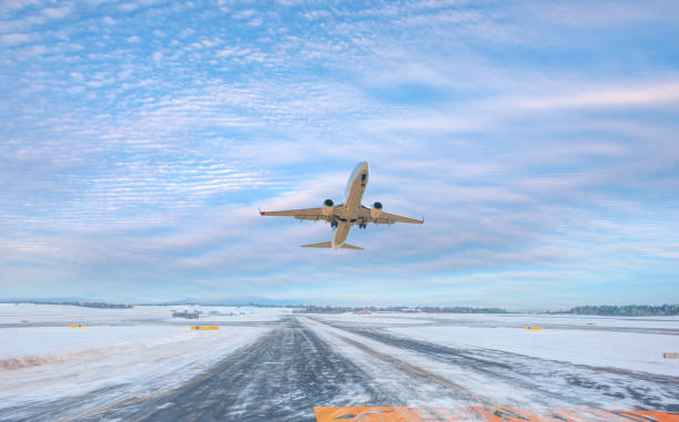 istock Passenger airplane fly up over take-off runway amazing white clouds in the background - Snow-covered airport 2009806873