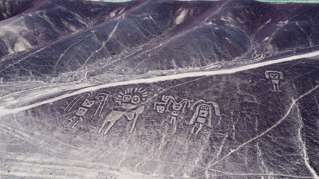Aerial view of mysterious humanoid creatures and the Nazca lines in the peruvian desert.